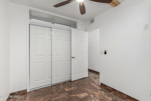 3940 E Timrod St Unit 118, Tucson, AZ 85711 - unfurnished bedroom with a closet, a ceiling fan, and dark marble finish flooring