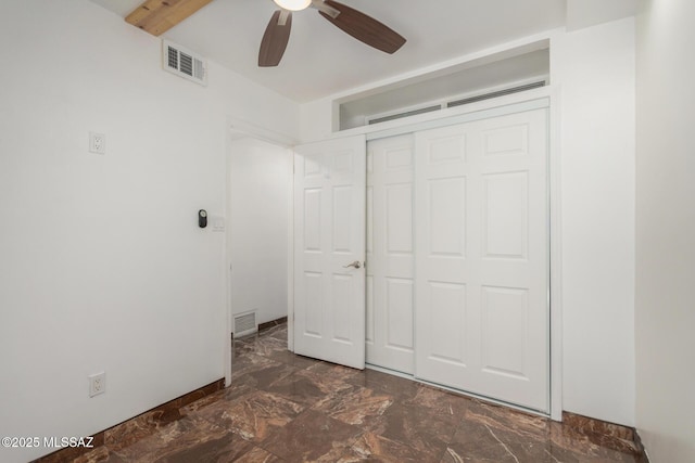 3940 E Timrod St Unit 118, Tucson, AZ 85711 - unfurnished bedroom with a closet, marble look tiles, and a ceiling fan