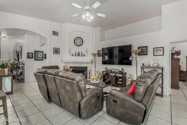 7157 W Odyssey Way, Tucson, AZ 85743 - living room with ceiling fan, light tile patterned floors, arched walkways, and a tiled fireplace