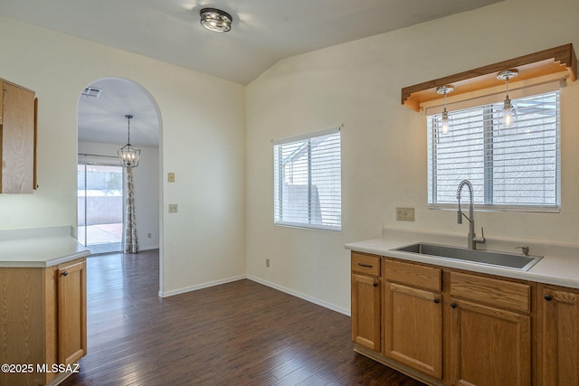 8954 E Pomegranate St, Tucson, AZ 85730 - kitchen featuring dark wood-type flooring, light countertops, hanging light fixtures, vaulted ceiling, and arched walkways