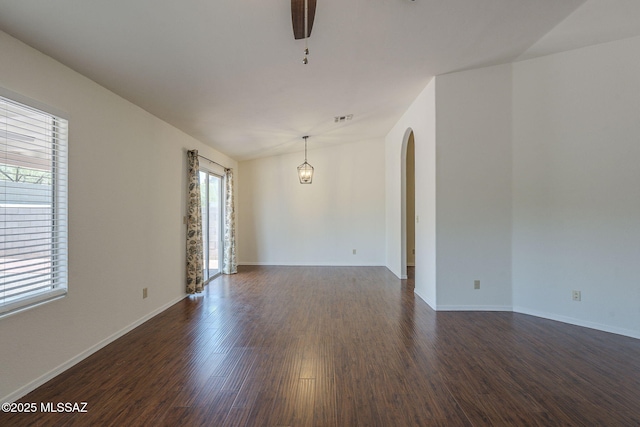 8954 E Pomegranate St, Tucson, AZ 85730 - empty room with dark wood-type flooring, arched walkways, and a ceiling fan