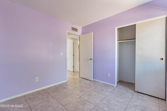 2340 S Window Rock Pl, Tucson, AZ 85710 - unfurnished bedroom featuring light tile patterned floors, baseboards, and a closet