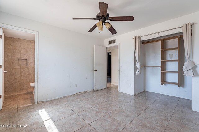 2340 S Window Rock Pl, Tucson, AZ 85710 - unfurnished bedroom with tile patterned floors, ensuite bathroom, a ceiling fan, and a closet