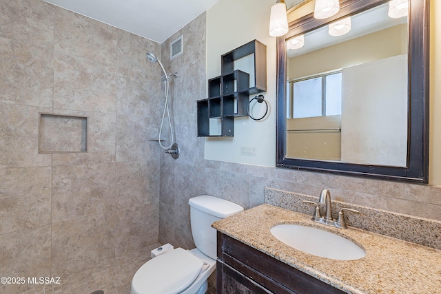 2340 S Window Rock Pl, Tucson, AZ 85710 - full bathroom featuring tiled shower, toilet, vanity, and tile walls