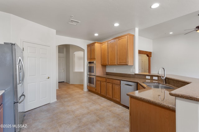 14243 E Whisper Trl, Vail, AZ 85641 - kitchen featuring stainless steel appliances, arched walkways, dark stone counters, recessed lighting, and a ceiling fan