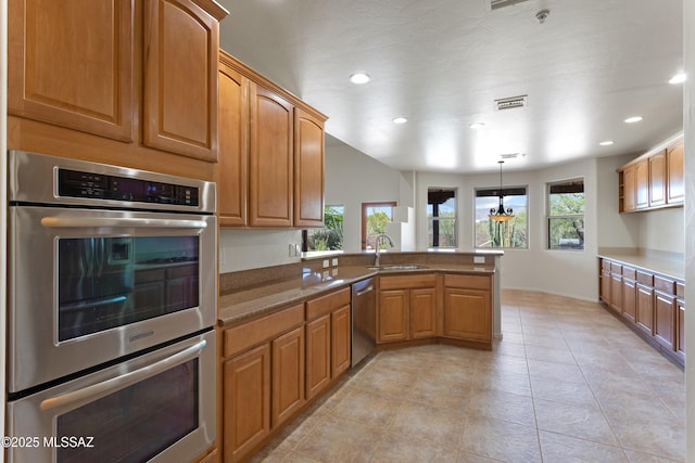 14243 E Whisper Trl, Vail, AZ 85641 - kitchen featuring appliances with stainless steel finishes, a peninsula, recessed lighting, brown cabinets, and light tile patterned floors