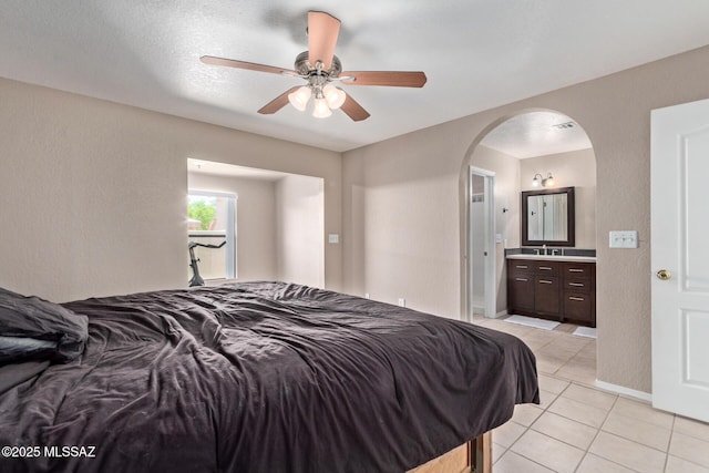 8172 N Streamside Ave, Tucson, AZ 85741 - bedroom with light tile patterned flooring, arched walkways, ensuite bath, baseboards, and ceiling fan