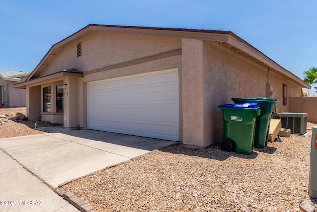 8172 N Streamside Ave, Tucson, AZ 85741 - view of side of property with stucco siding, a garage, driveway, and central AC
