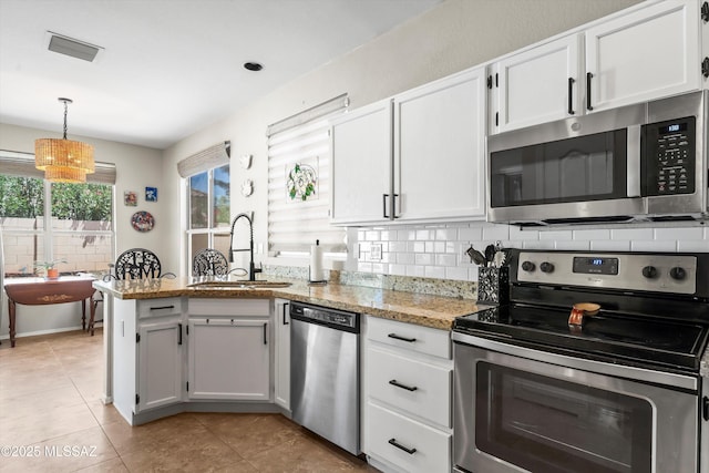 9860 N Western Sky Pl, Tucson, AZ 85742 - kitchen with appliances with stainless steel finishes, a sink, a peninsula, white cabinetry, and light tile patterned flooring