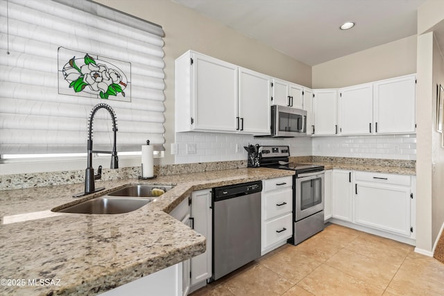 9860 N Western Sky Pl, Tucson, AZ 85742 - kitchen featuring appliances with stainless steel finishes, a sink, tasteful backsplash, white cabinets, and light stone countertops
