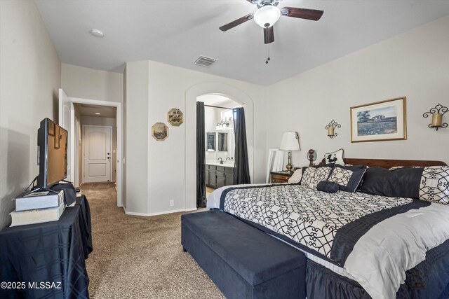 9860 N Western Sky Pl, Tucson, AZ 85742 - carpeted bedroom with baseboards, arched walkways, ensuite bath, and a ceiling fan