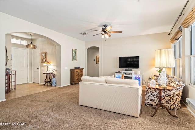 9860 N Western Sky Pl, Tucson, AZ 85742 - carpeted living room featuring arched walkways, ceiling fan, and baseboards