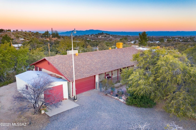150 E Nuestro St, Oracle, AZ 85623 - view of front of house featuring gravel driveway, a garage, a shingled roof, and a chimney