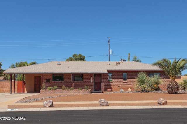 1117 S Carnegie Dr, Tucson, AZ 85710 - single story home with an attached carport, driveway, a shingled roof, and brick siding