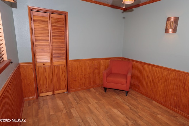 1117 S Carnegie Dr, Tucson, AZ 85710 - unfurnished room featuring a wainscoted wall, wood finished floors, wooden walls, a ceiling fan, and crown molding