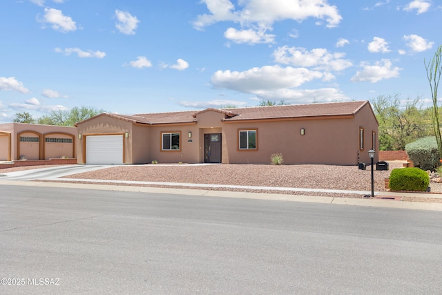 1960 S San Vincent Dr, Green Valley, AZ 85614 - view of front of property featuring an attached garage, concrete driveway, stucco siding, and a tile roof