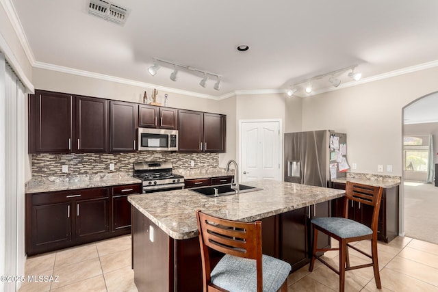 6733 S Stone Fly Dr, Tucson, AZ 85757 - kitchen with appliances with stainless steel finishes, a sink, rail lighting, light tile patterned floors, and a kitchen bar