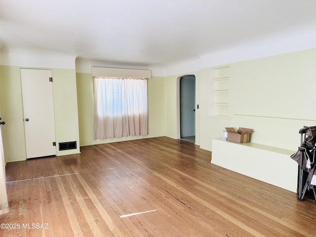 41 S Main St, Pima, AZ 85543 - unfurnished living room with arched walkways, hardwood / wood-style flooring, and built in features