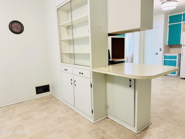 41 S Main St, Pima, AZ 85543 - kitchen featuring a peninsula, light countertops, and freestanding refrigerator