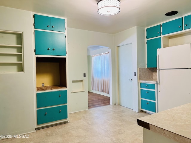 41 S Main St, Pima, AZ 85543 - kitchen with freestanding refrigerator, arched walkways, and light countertops