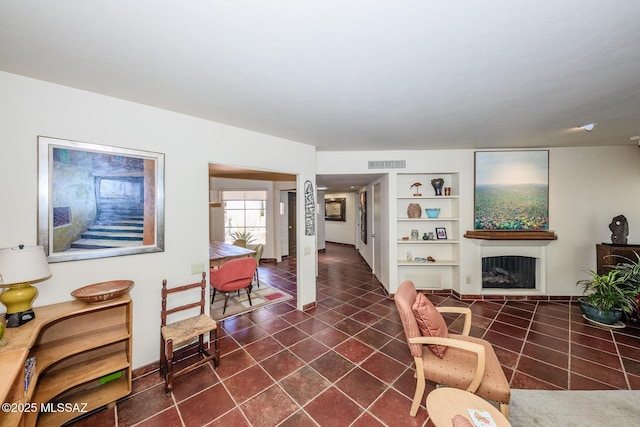 2600 E Skyline Dr Unit 21, Tucson, AZ 85718 - living room with built in shelves, dark tile patterned floors, a fireplace, and baseboards