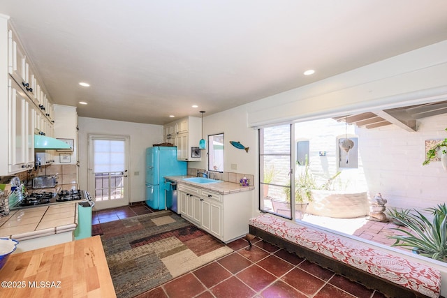2600 E Skyline Dr Unit 21, Tucson, AZ 85718 - kitchen with a sink, gas stove, dishwasher, white cabinets, and under cabinet range hood