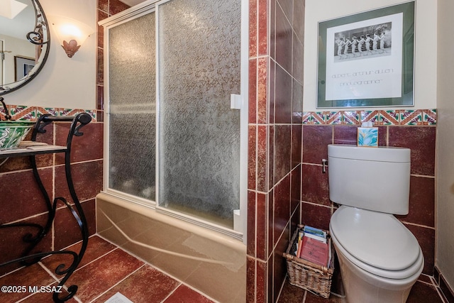 2600 E Skyline Dr Unit 21, Tucson, AZ 85718 - full bath featuring tile walls, toilet, tile patterned floors, wainscoting, and shower / bath combination with glass door