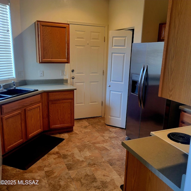 536 W Deerview Ct, Green Valley, AZ 85614 - kitchen featuring stainless steel refrigerator with ice dispenser, brown cabinets, healthy amount of natural light, and a sink