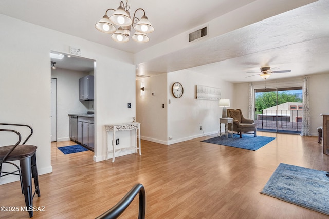 625 S Prudence Rd Apt 201, Tucson, AZ 85710 - living area featuring light wood-style floors, a chandelier, ceiling fan, and baseboards