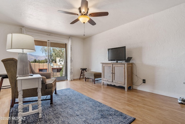 625 S Prudence Rd Apt 201, Tucson, AZ 85710 - living area featuring a ceiling fan, wood finished floors, a textured wall, and baseboards
