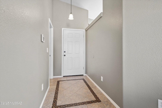 8079 N Eve Ann Way, Tucson, AZ 85741 - doorway to outside with inlaid floor details, baseboards, tile patterned floors, and a high ceiling