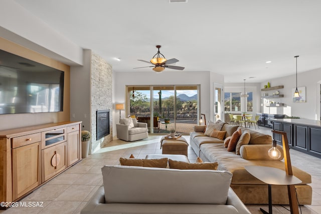 12475 N Faraway Wash Trl, Marana, AZ 85658 - living area featuring a fireplace, ceiling fan, and light tile patterned floors