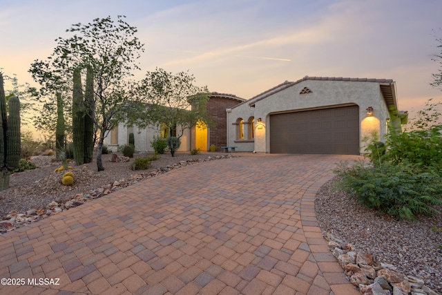 12475 N Faraway Wash Trl, Marana, AZ 85658 - mediterranean / spanish-style home with driveway, an attached garage, and stucco siding