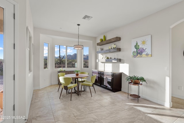 12475 N Faraway Wash Trl, Marana, AZ 85658 - dining space featuring arched walkways, a mountain view, and light tile patterned flooring