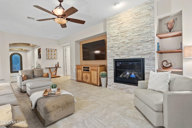 12475 N Faraway Wash Trl, Marana, AZ 85658 - living room with a ceiling fan, arched walkways, a fireplace, and light tile patterned floors
