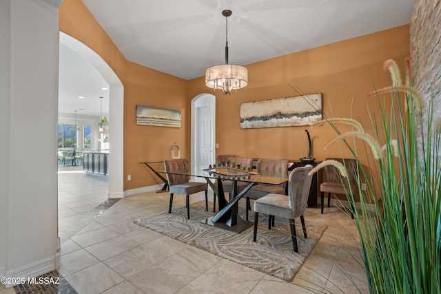 12475 N Faraway Wash Trl, Marana, AZ 85658 - dining room with arched walkways, a chandelier, and tile patterned floors