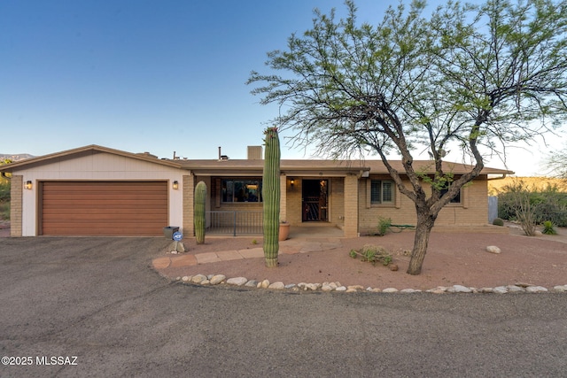 4990 N Kolb Rd, Tucson, AZ 85750 - ranch-style home featuring asphalt driveway, a garage, brick siding, and a porch