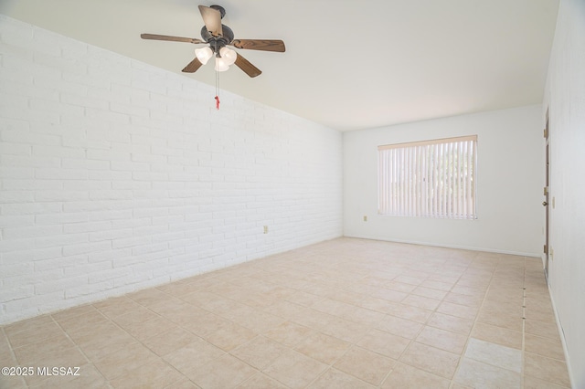1438 W De Nada, Green Valley, AZ 85622 - empty room featuring brick wall, a ceiling fan, and light tile patterned flooring