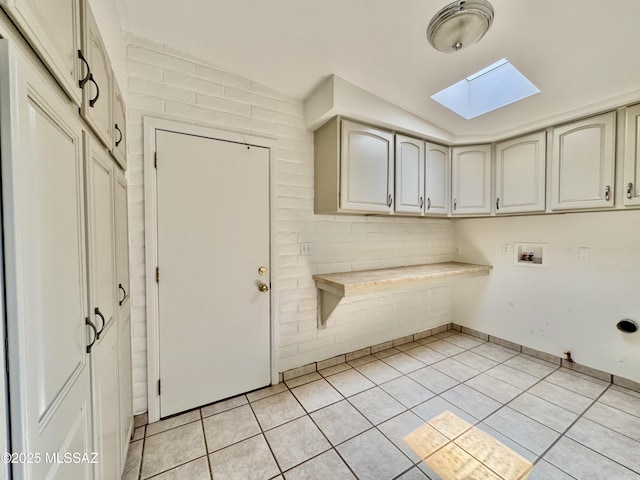 7621 N Placita De Los Amigos, Tucson, AZ 85704 - laundry room featuring a skylight, cabinet space, light tile patterned flooring, and washer hookup