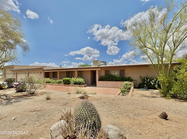 7621 N Placita De Los Amigos, Tucson, AZ 85704 - view of front of house with an attached garage and stucco siding