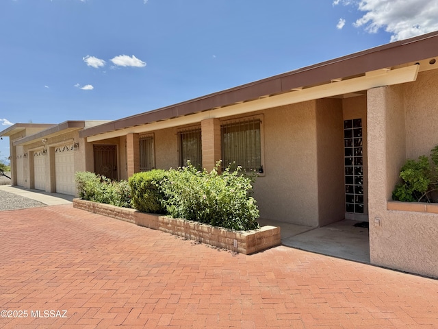 7621 N Placita De Los Amigos, Tucson, AZ 85704 - view of front of property featuring stucco siding, a garage, and driveway