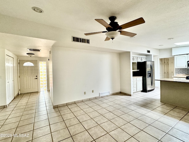 7621 N Placita De Los Amigos, Tucson, AZ 85704 - unfurnished living room featuring light tile patterned floors, a ceiling fan, and a textured ceiling