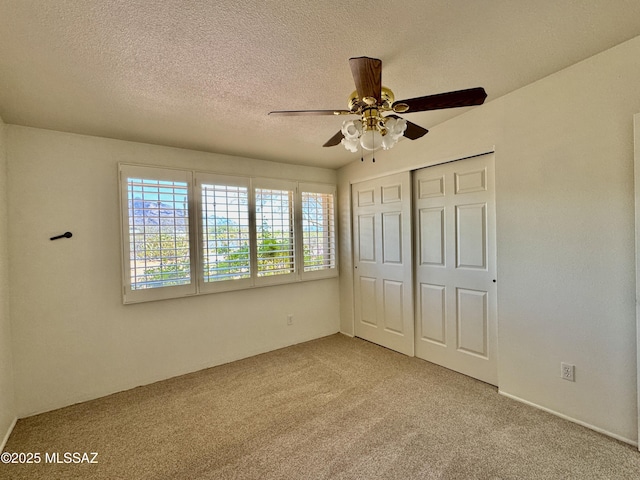 7621 N Placita De Los Amigos, Tucson, AZ 85704 - unfurnished bedroom with light colored carpet, a closet, a textured ceiling, and a ceiling fan