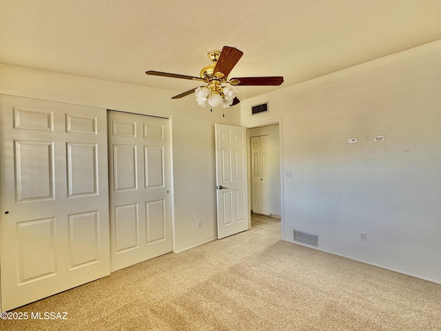 7621 N Placita De Los Amigos, Tucson, AZ 85704 - unfurnished bedroom with light colored carpet, a closet, a ceiling fan, and a textured ceiling