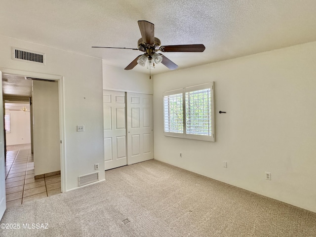 7621 N Placita De Los Amigos, Tucson, AZ 85704 - unfurnished bedroom with carpet, a textured ceiling, a closet, and a ceiling fan