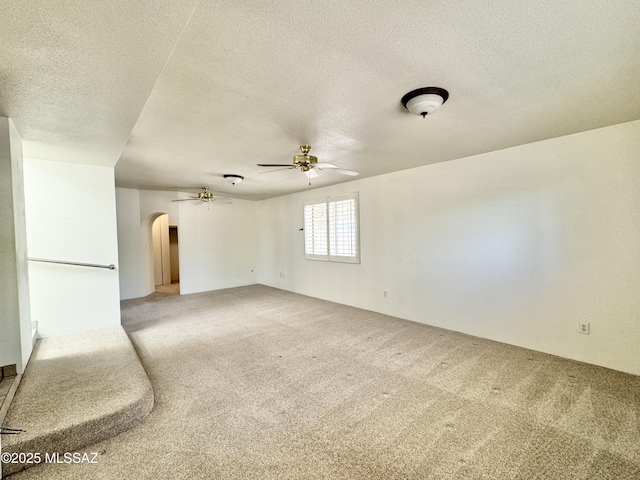 7621 N Placita De Los Amigos, Tucson, AZ 85704 - unfurnished room with arched walkways, light carpet, a ceiling fan, and a textured ceiling