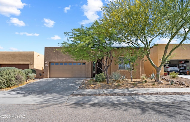 8984 E Wright School Loop, Tucson, AZ 85715 - pueblo revival-style home featuring a garage, driveway, and stucco siding
