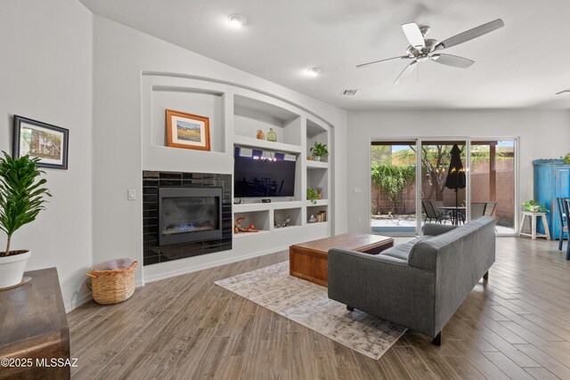 8984 E Wright School Loop, Tucson, AZ 85715 - living area featuring built in features, wood finished floors, ceiling fan, and a tile fireplace