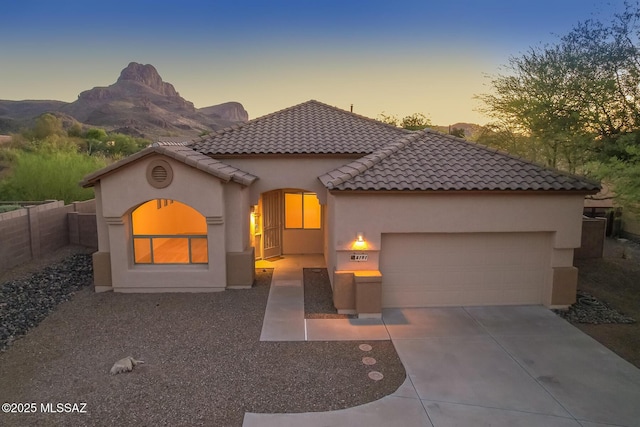 8191 N White Stallion Pl, Tucson, AZ 85743 - mediterranean / spanish-style home with concrete driveway, stucco siding, a garage, a tiled roof, and a mountain view