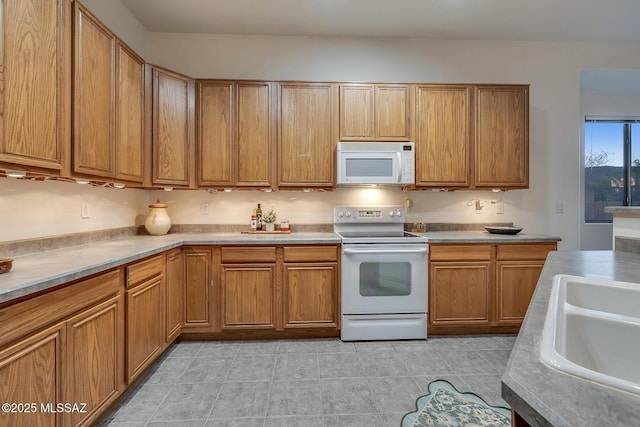 8191 N White Stallion Pl, Tucson, AZ 85743 - kitchen featuring white appliances, light countertops, brown cabinetry, and light tile patterned floors